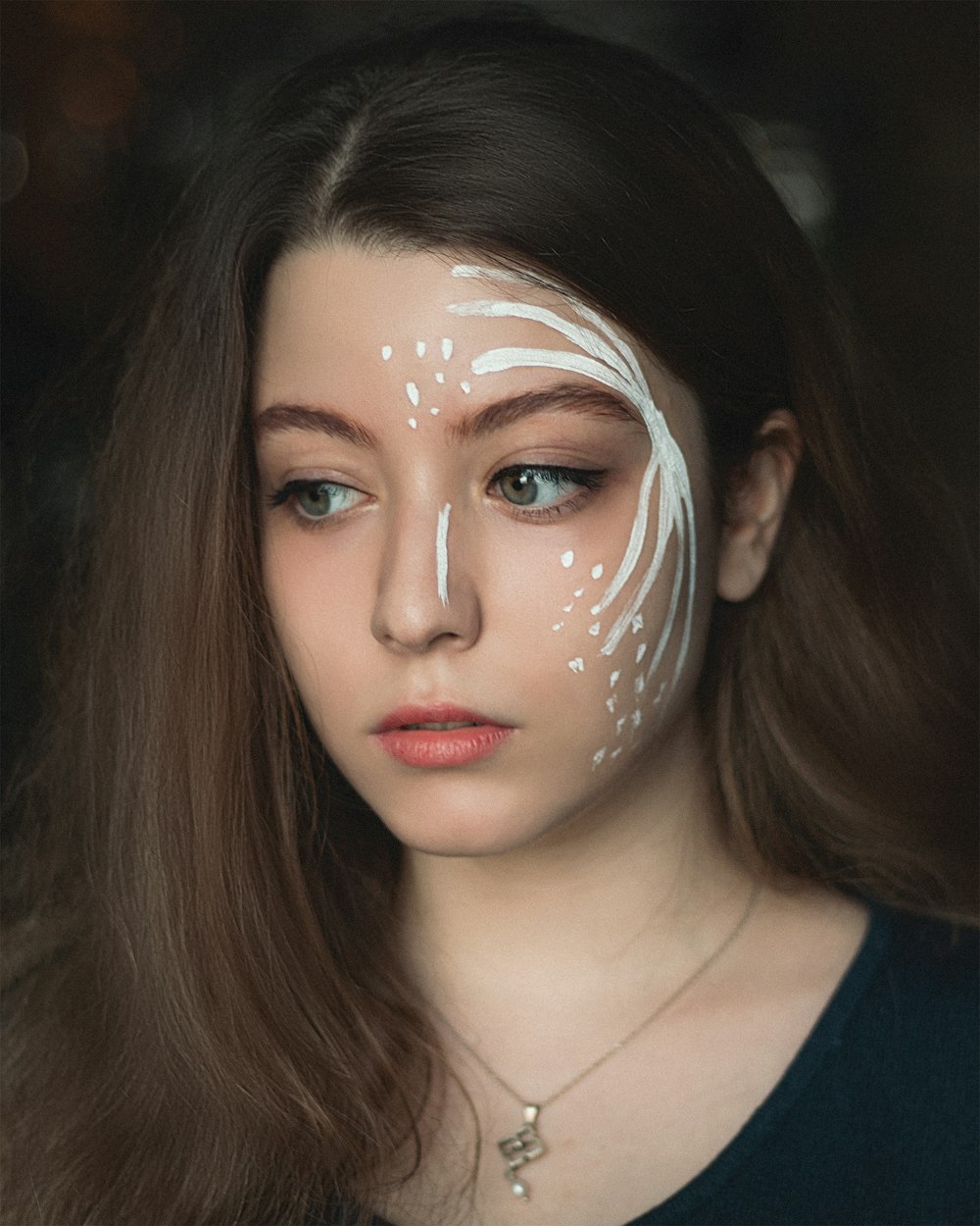 woman in black v neck shirt with silver and white face mask