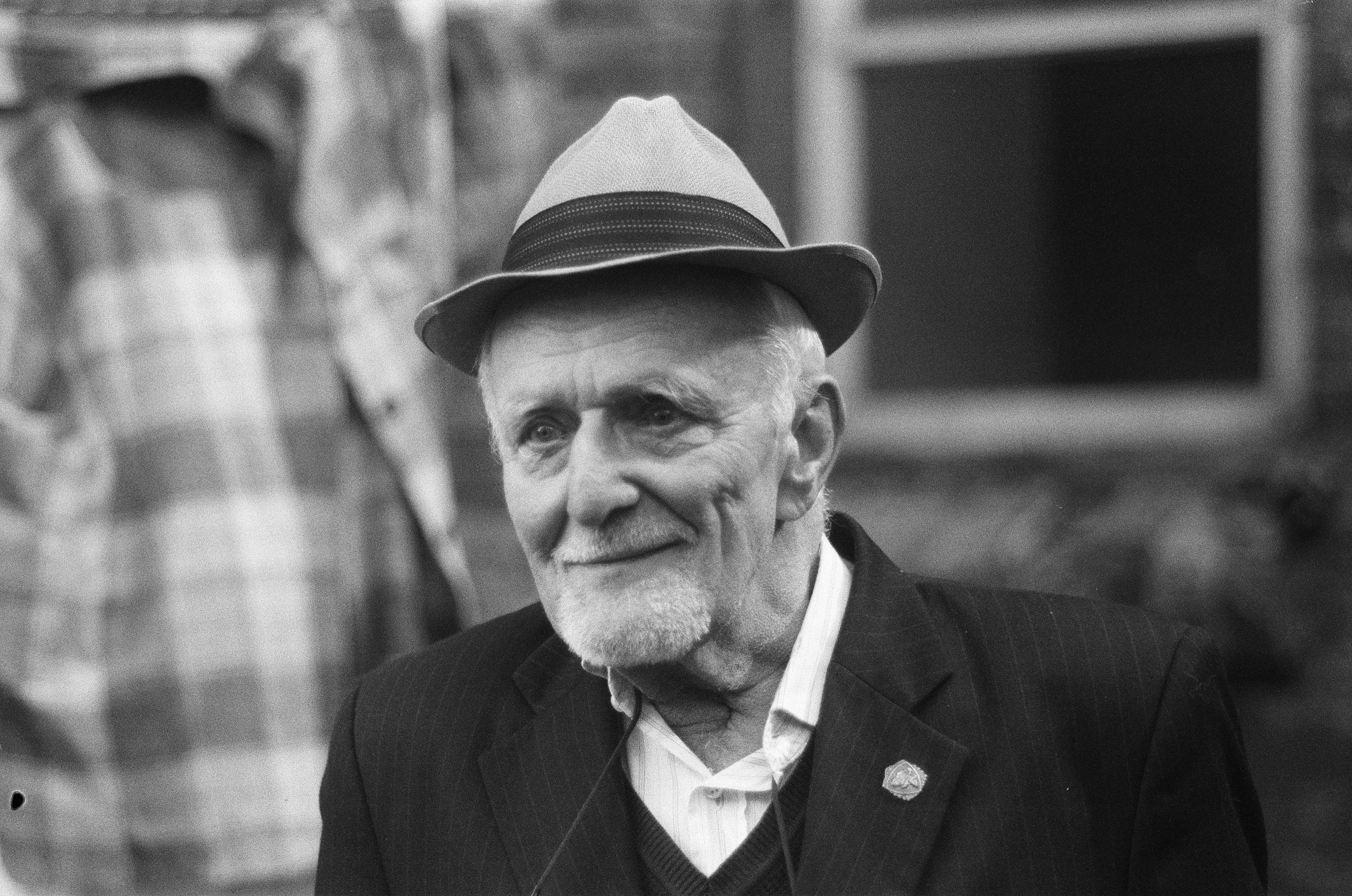 man in black suit jacket wearing black hat