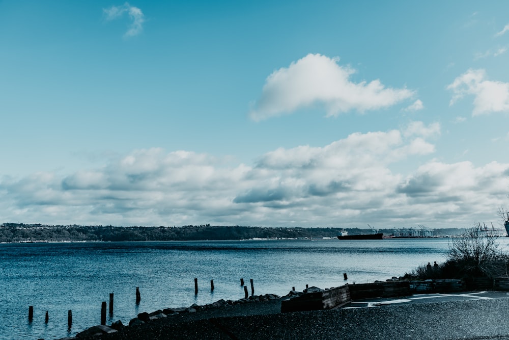 body of water under blue sky and white clouds during daytime