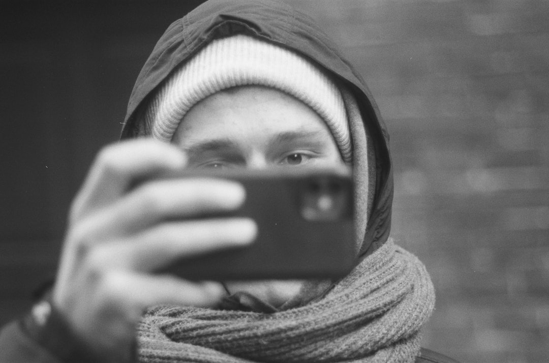 grayscale photo of woman covering her face with scarf