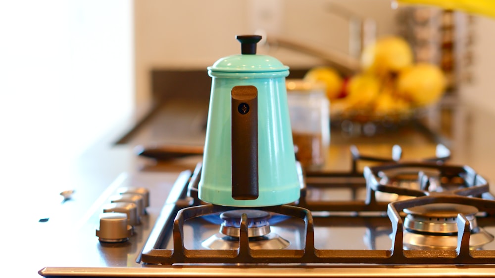 blue and white plastic pitcher on gas stove