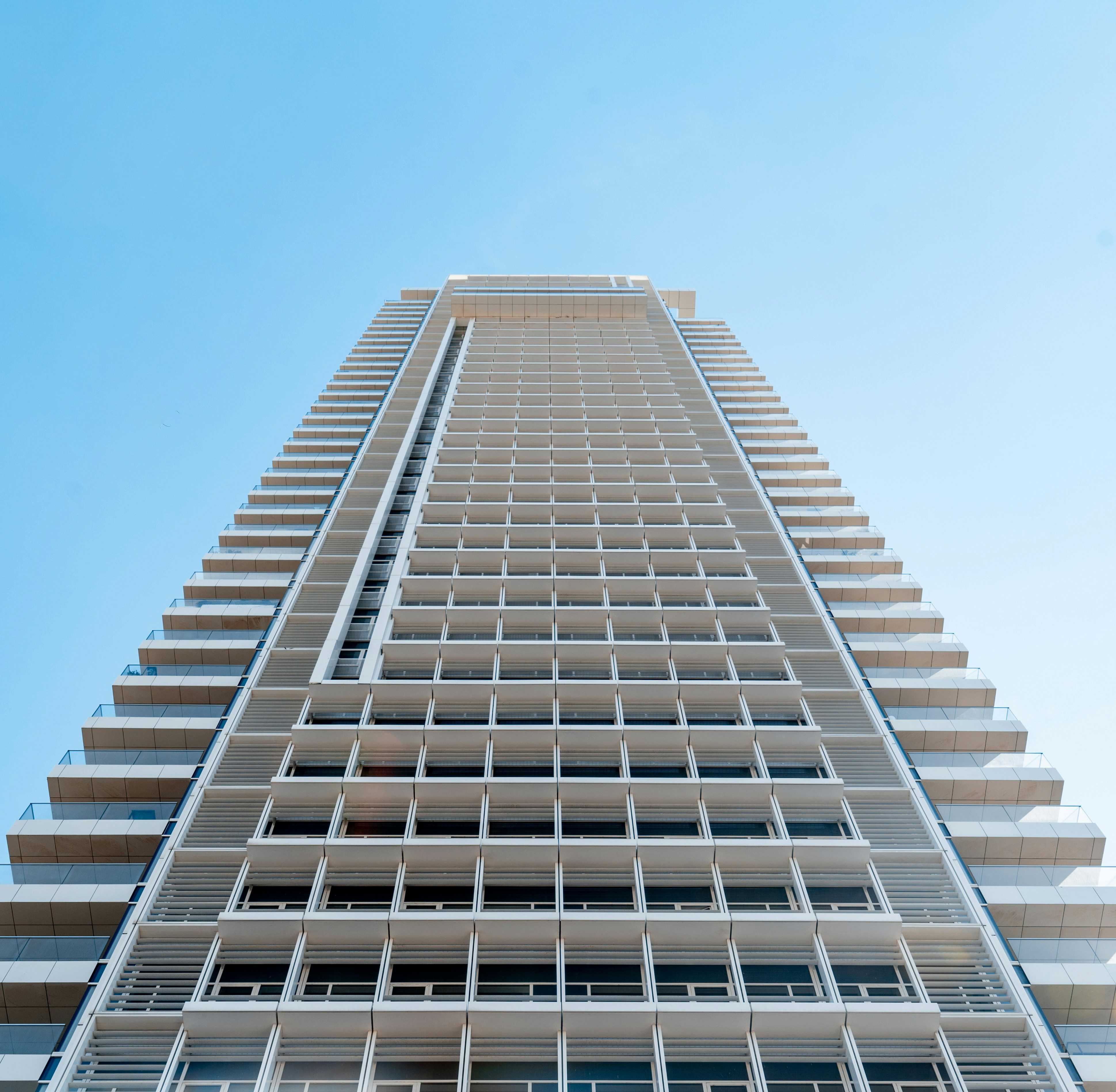 facade of a multi-storey modern residential building stretching into the sky
