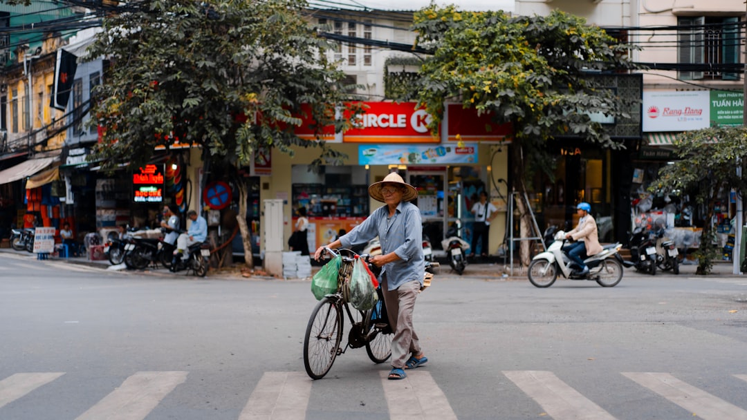 man in white dress shirt riding on bicycle during daytime