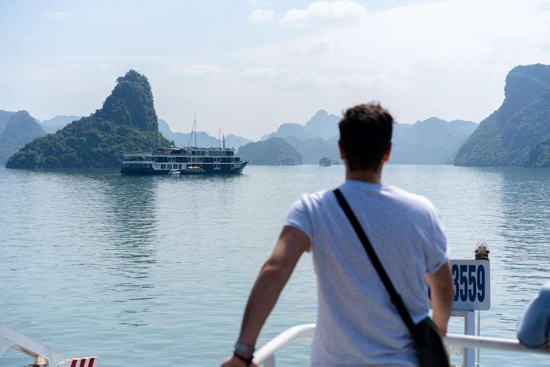 man in white t-shirt standing on boat during daytime