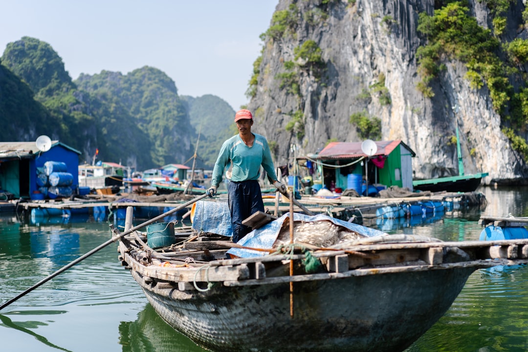 man in blue shirt standing on boat on river during daytime