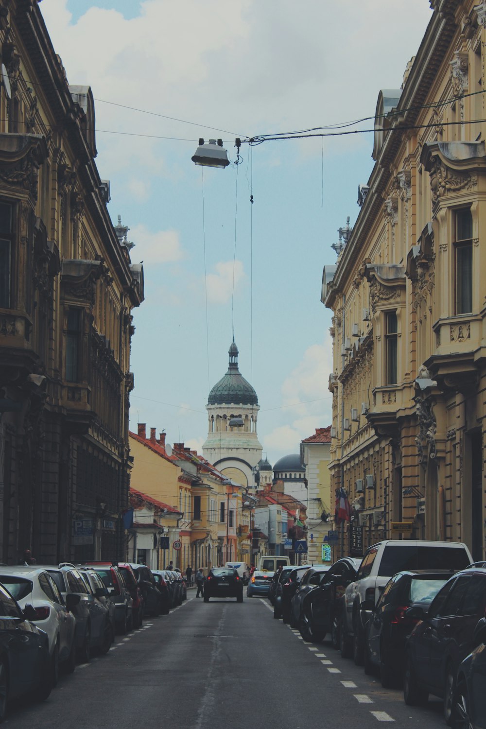 cars parked on street in between buildings during daytime