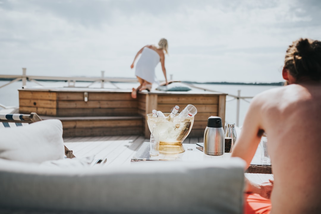 woman in white bikini sitting on white chair near body of water during daytime