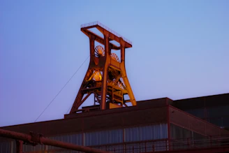 Modern industrial warehouse at sunset with trucks and golden light highlighting structure