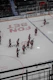 A lively group of adult hockey players clinking beer mugs on the ice rink.