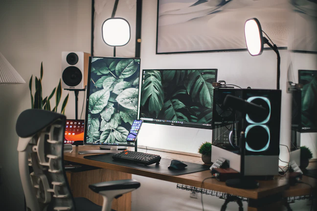 A vibrant workspace showing a gaming chair and dual monitors with tech gadgets around