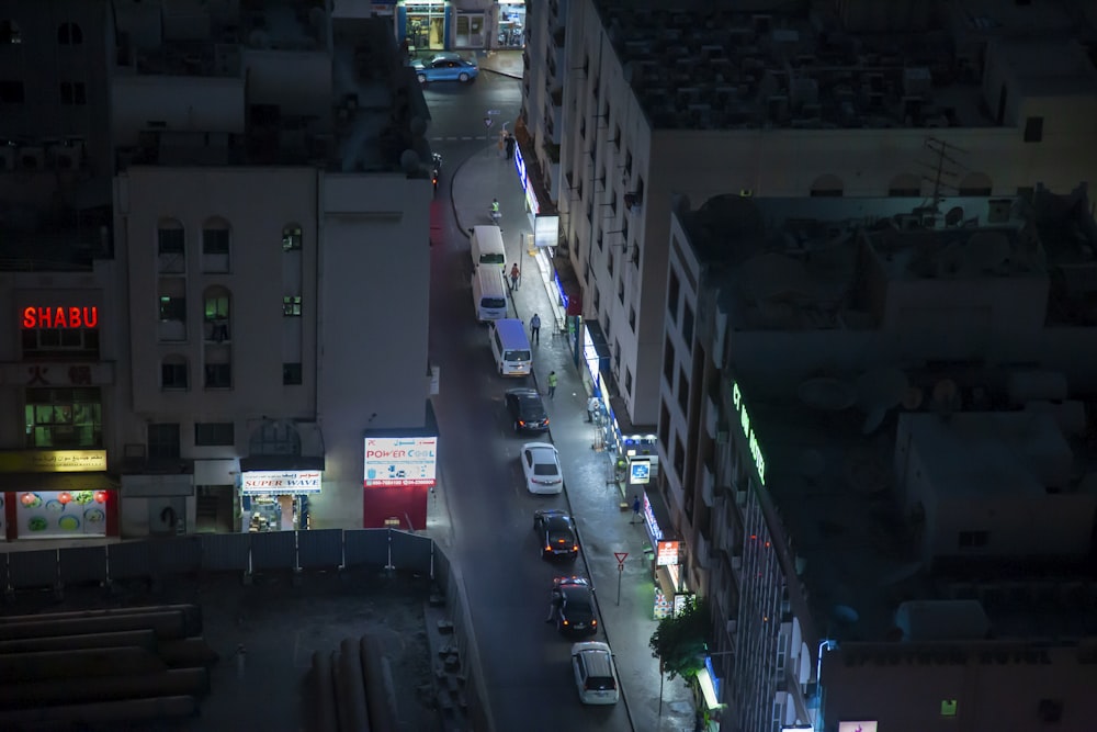 cars parked on the side of the road in between high rise buildings during daytime