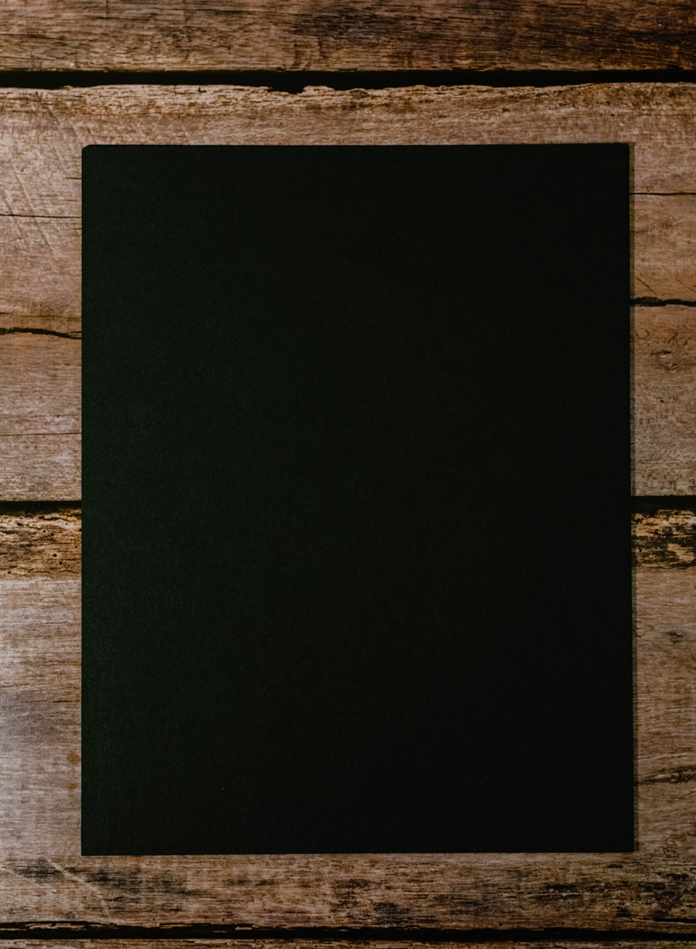 Schwarzes Papier auf braunem Holztisch