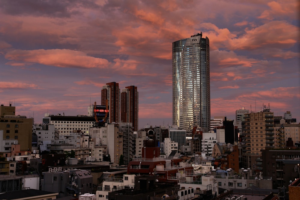 Skyline der Stadt unter orange und grau bewölktem Himmel bei Sonnenuntergang