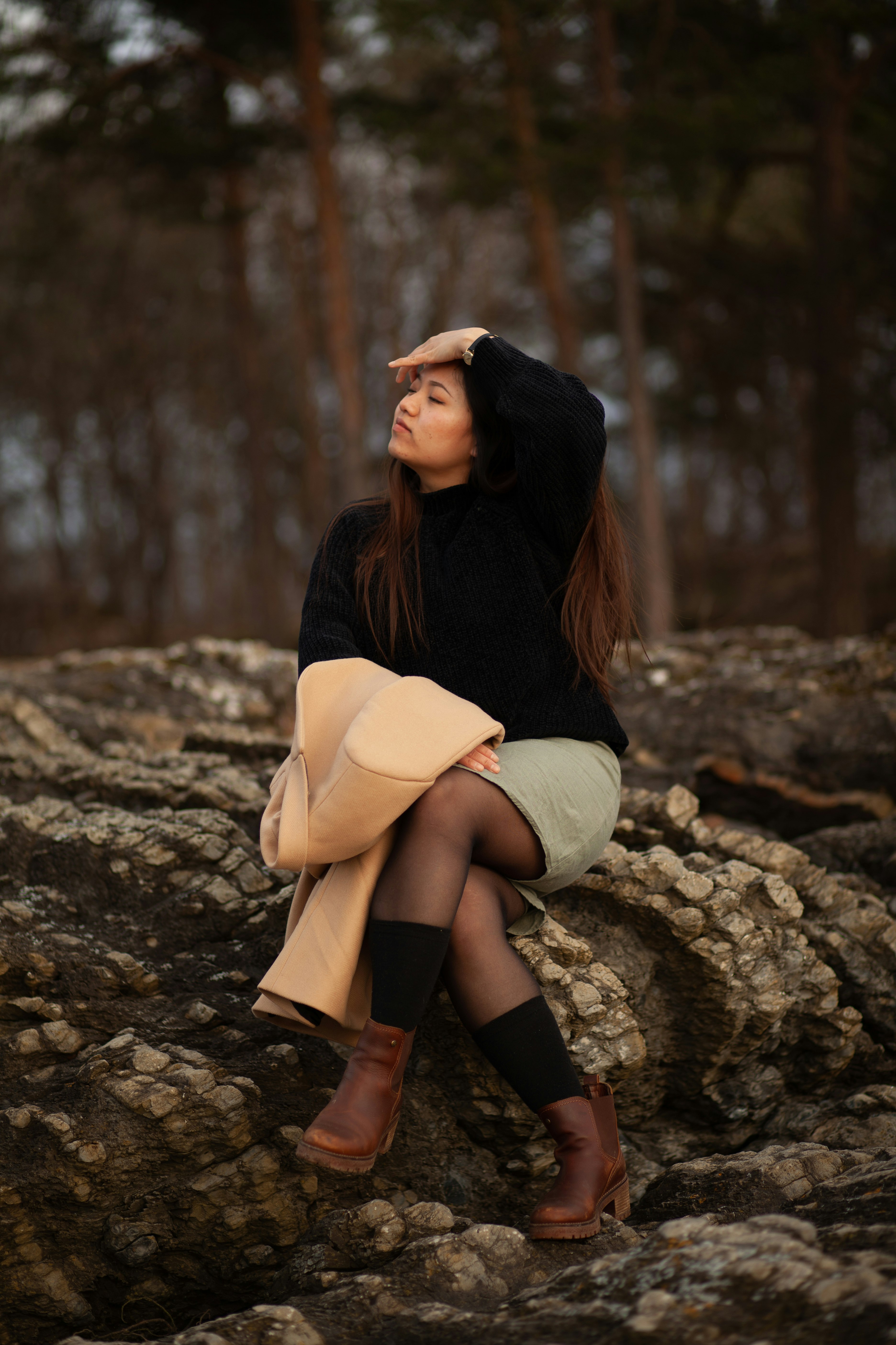 woman in black long sleeve shirt and white skirt sitting on rock