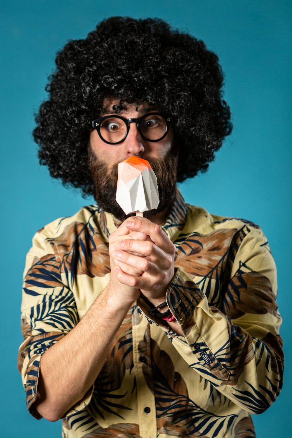 man in brown and black camouflage jacket holding white and red heart shaped lollipop