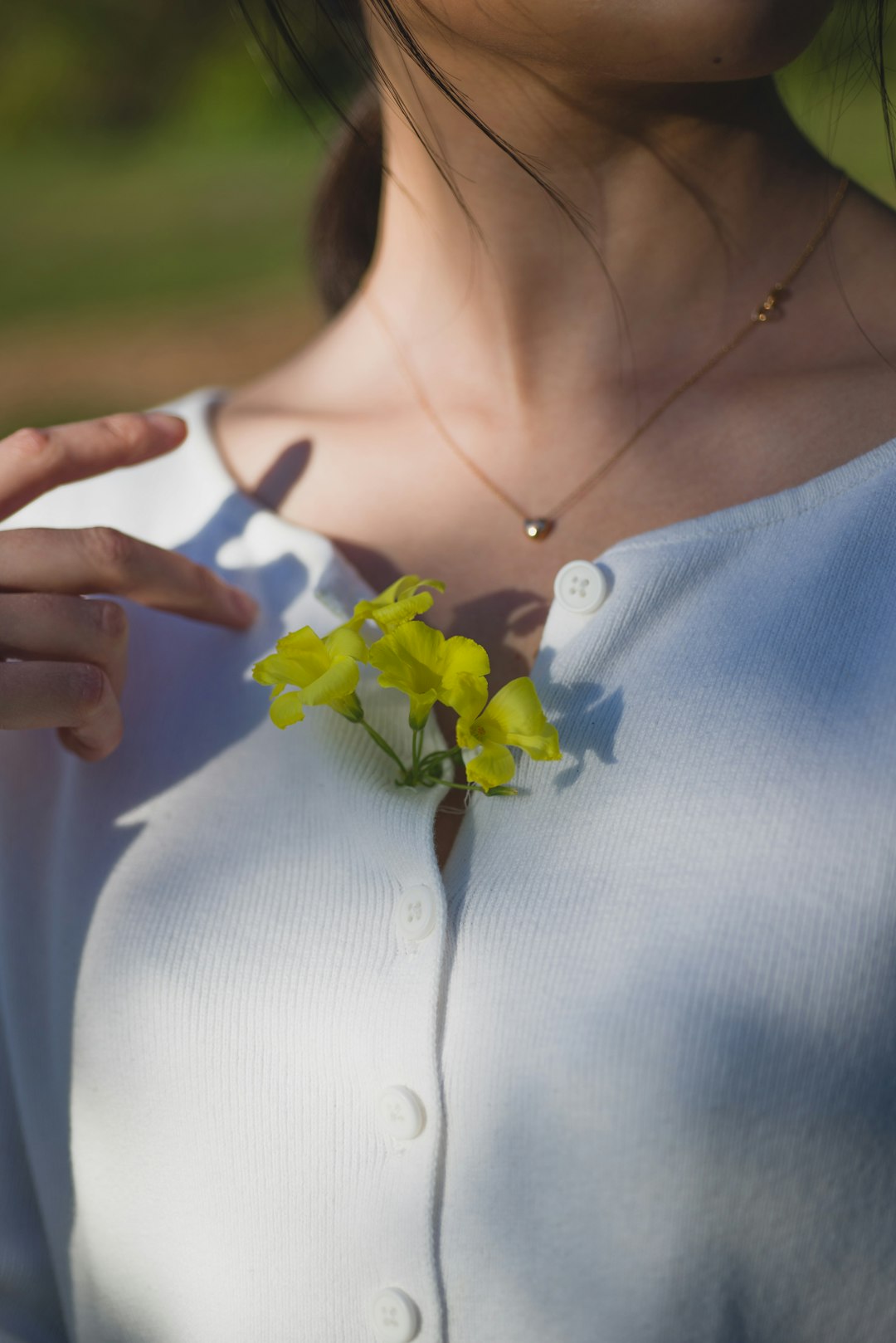 woman in white dress with yellow flower on her left ear