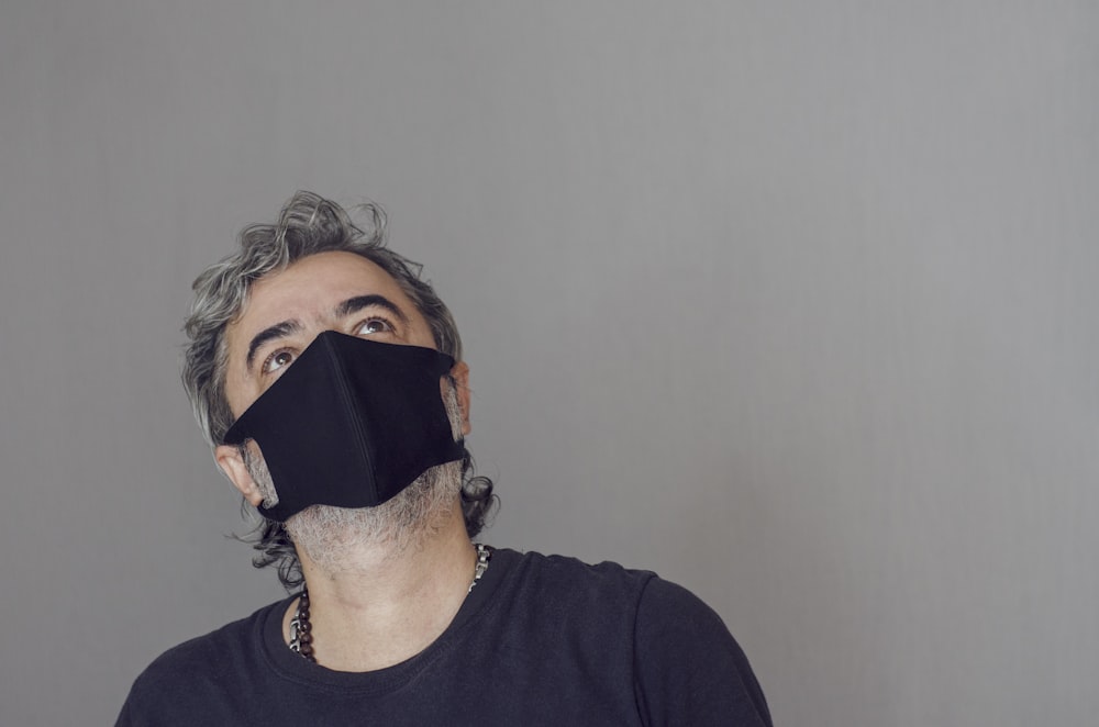 man in black crew neck shirt wearing black face mask