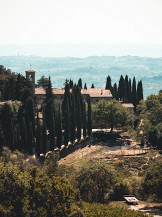 Wide view of Torre Palazzone estate nestled among cypress-lined paths.