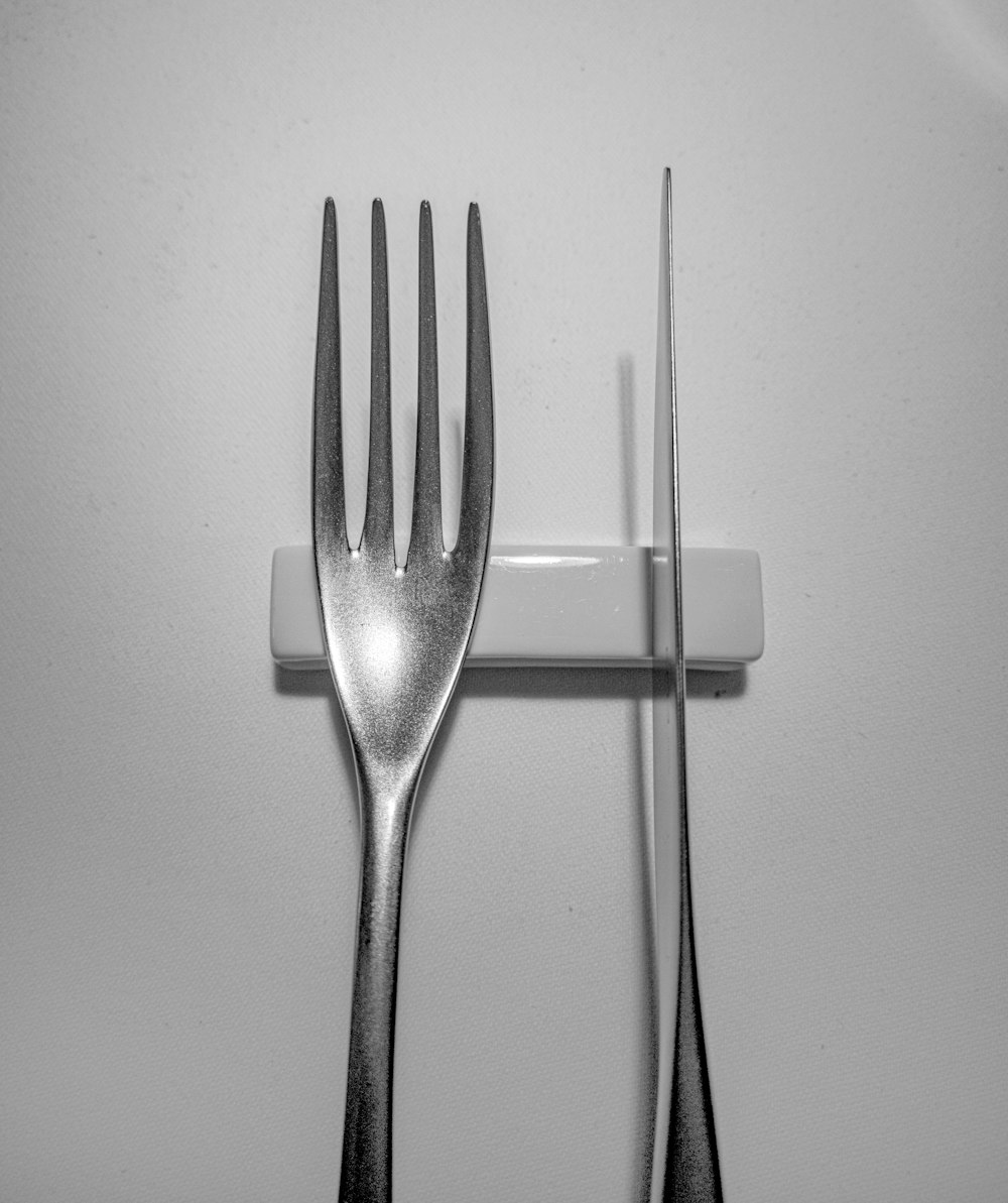 stainless steel fork on white surface