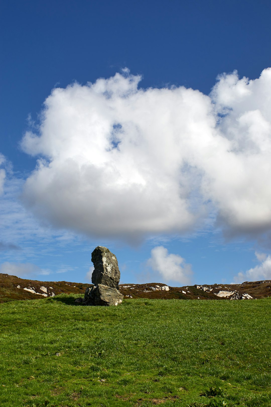 gray rock formation under white clouds and blue sky during daytime