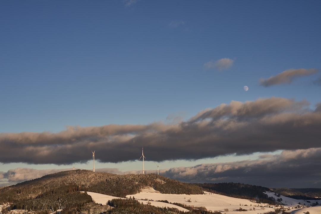 wind turbines on brown field under blue sky during daytime