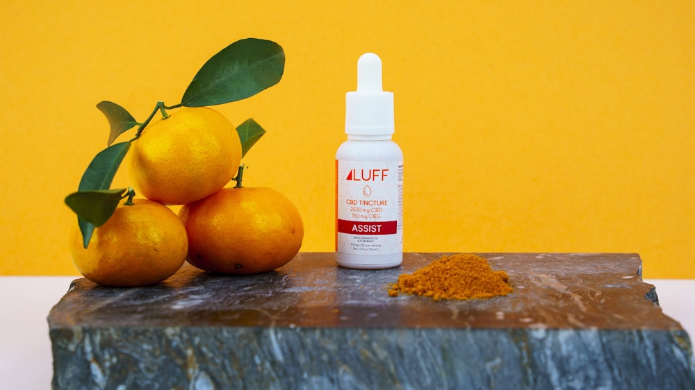 white plastic bottle beside yellow citrus fruits