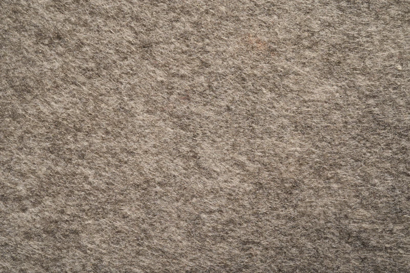 Close-up of brown wool carpet texture underfoot