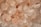 A close-up view of variously sized pink and white crystals, resembling salt or mineral stones. The textures appear rough and granular, with some stones exhibiting a translucent quality.