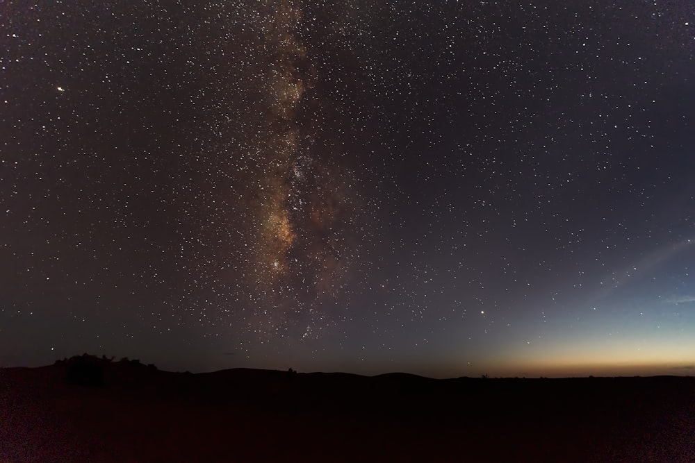 silhouette of mountain under starry night