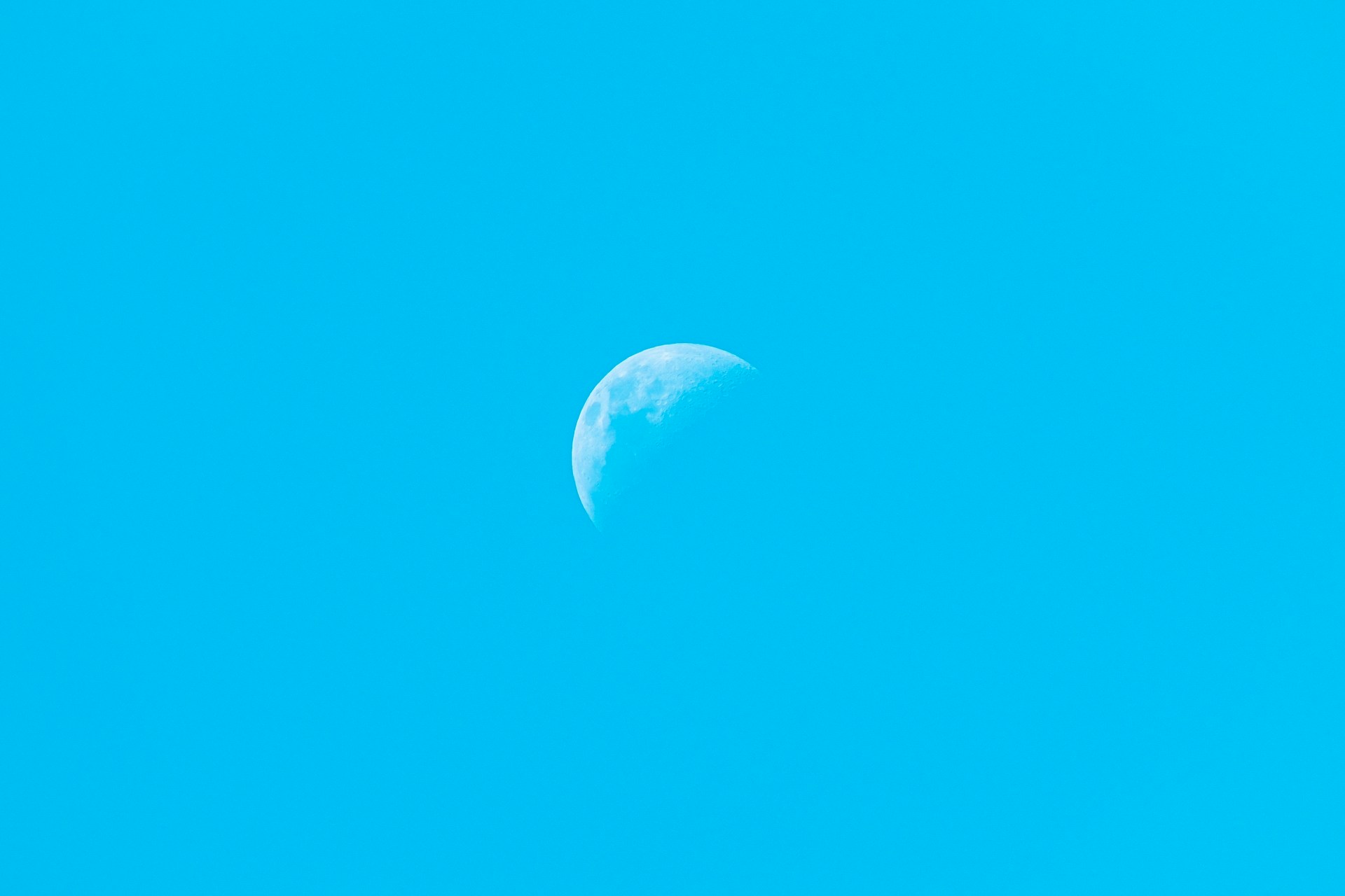 white half moon in blue sky