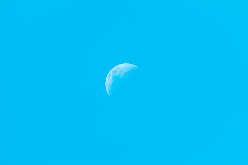 white half moon in blue sky