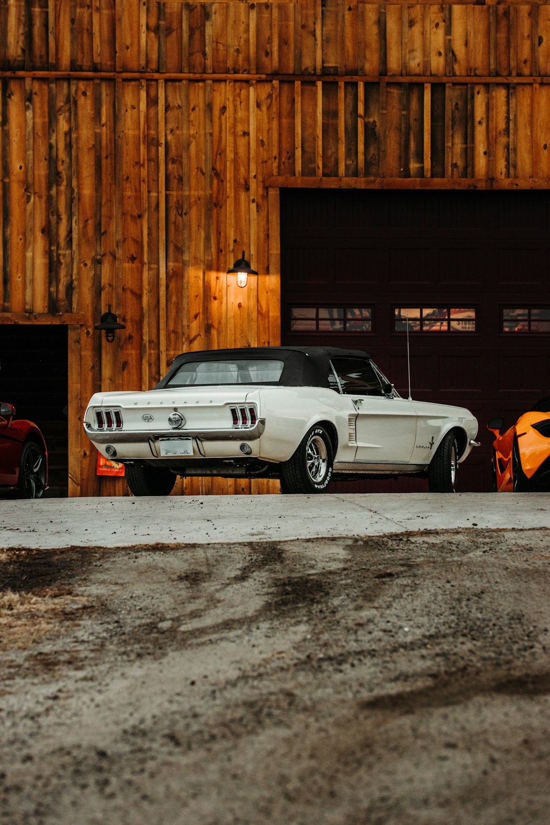 white chevrolet camaro parked beside brown wooden wall