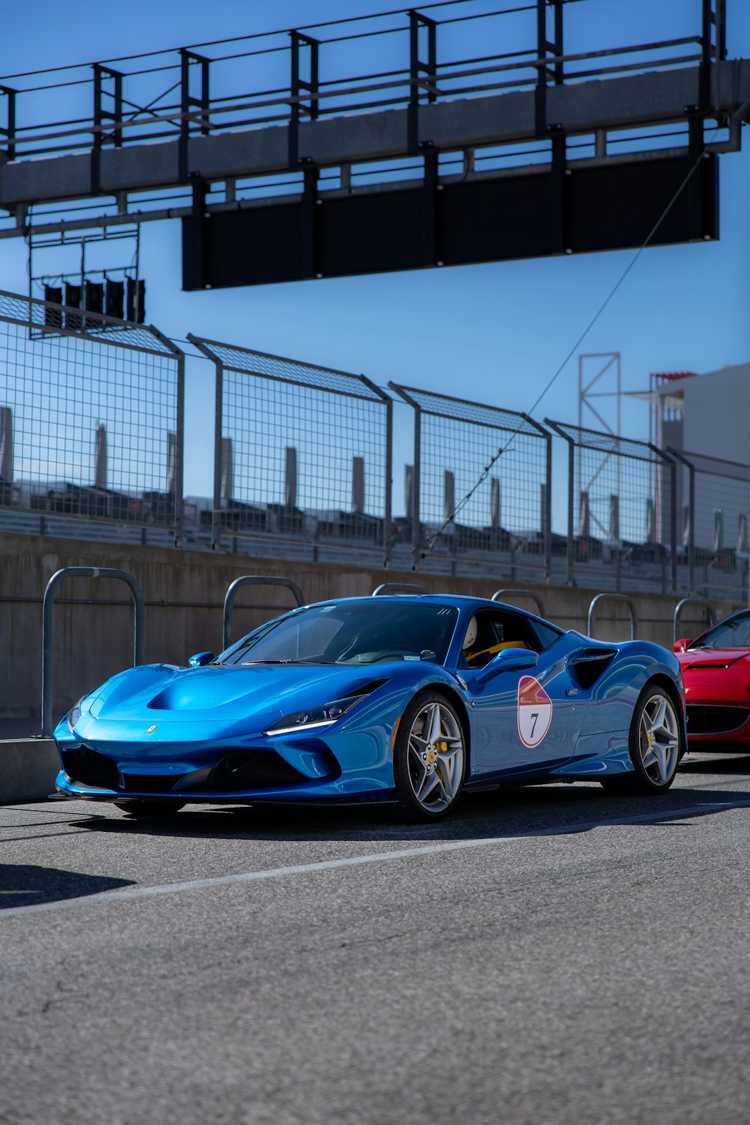 blue and red ferrari coupe parked on gray concrete pavement during daytime