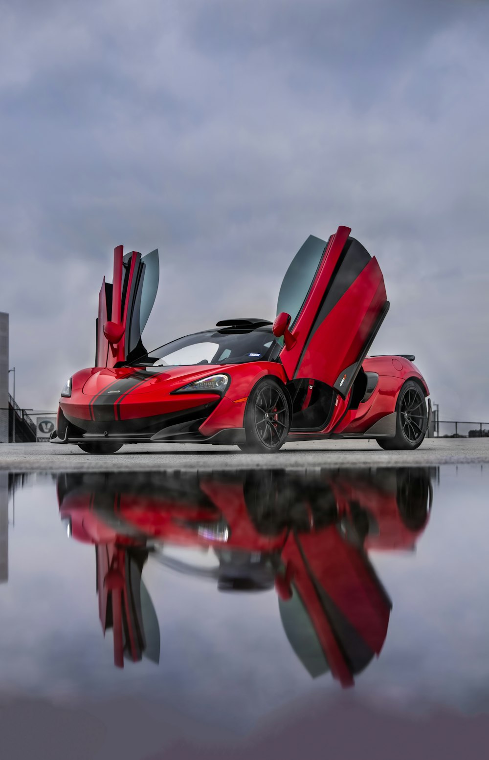 Auto sportiva rossa e nera sul molo durante il giorno