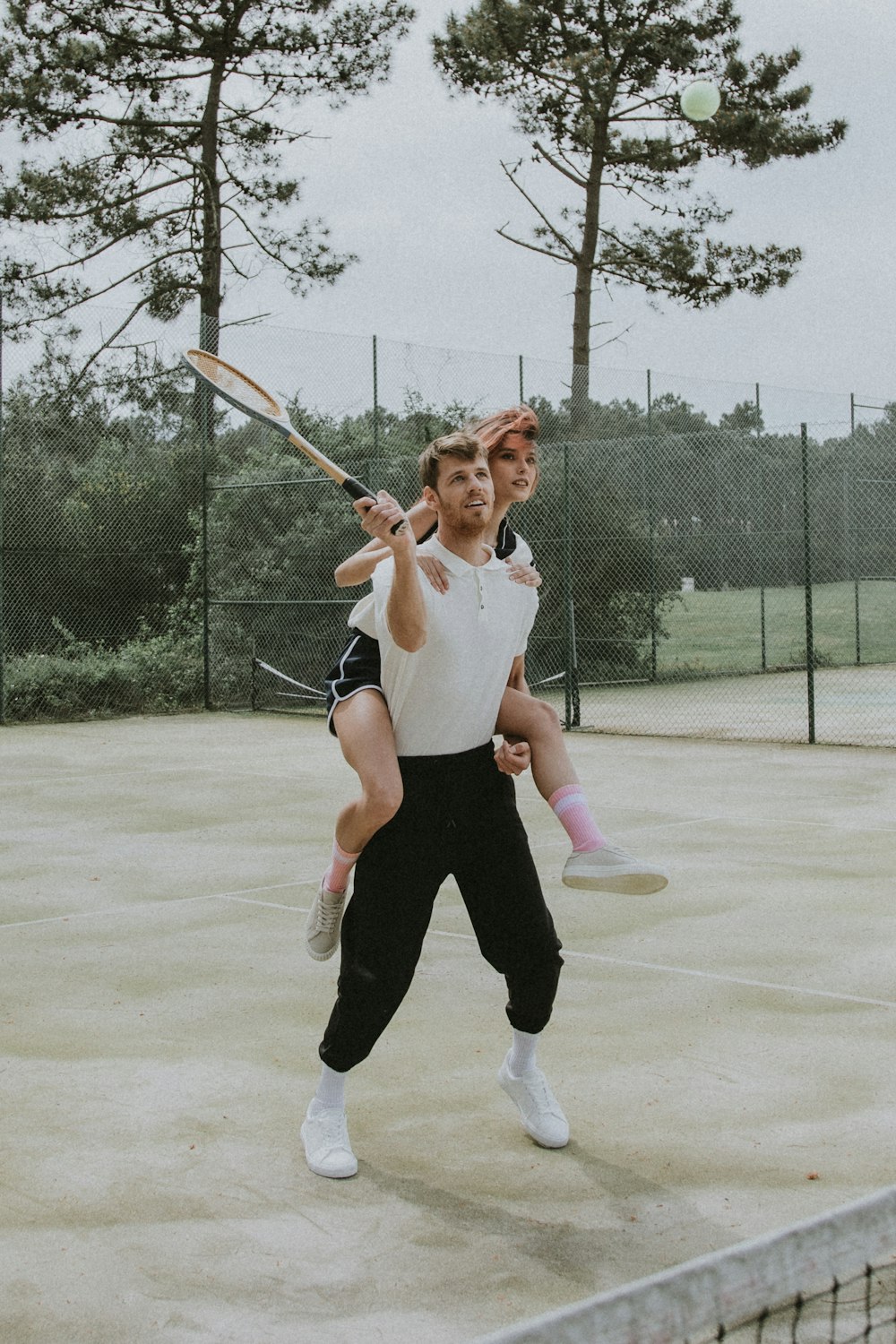 woman in white long sleeve shirt and black pants holding baseball bat