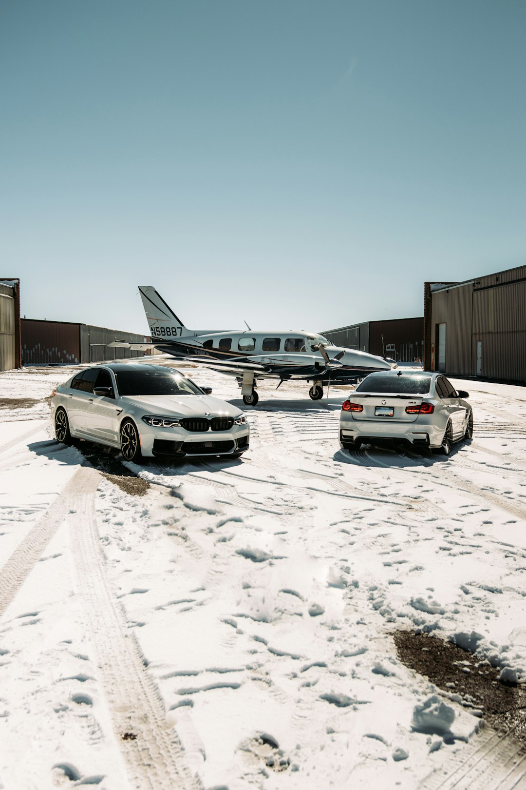 white sedan parked beside white car during daytime