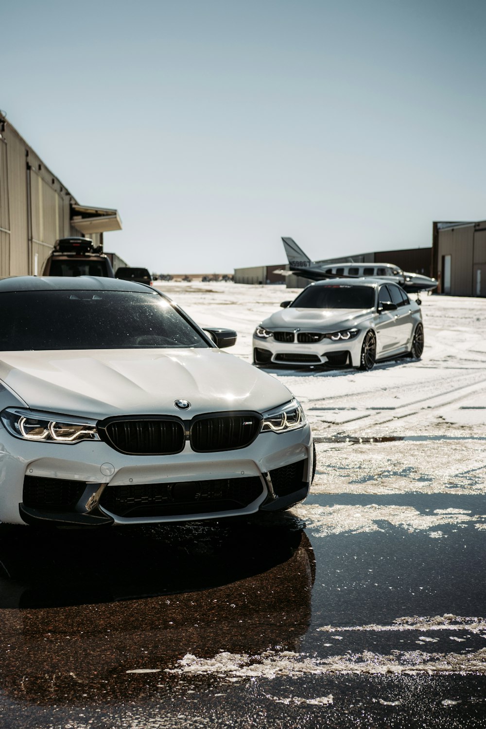 Coche BMW plateado aparcado sobre suelo de hormigón gris durante el día