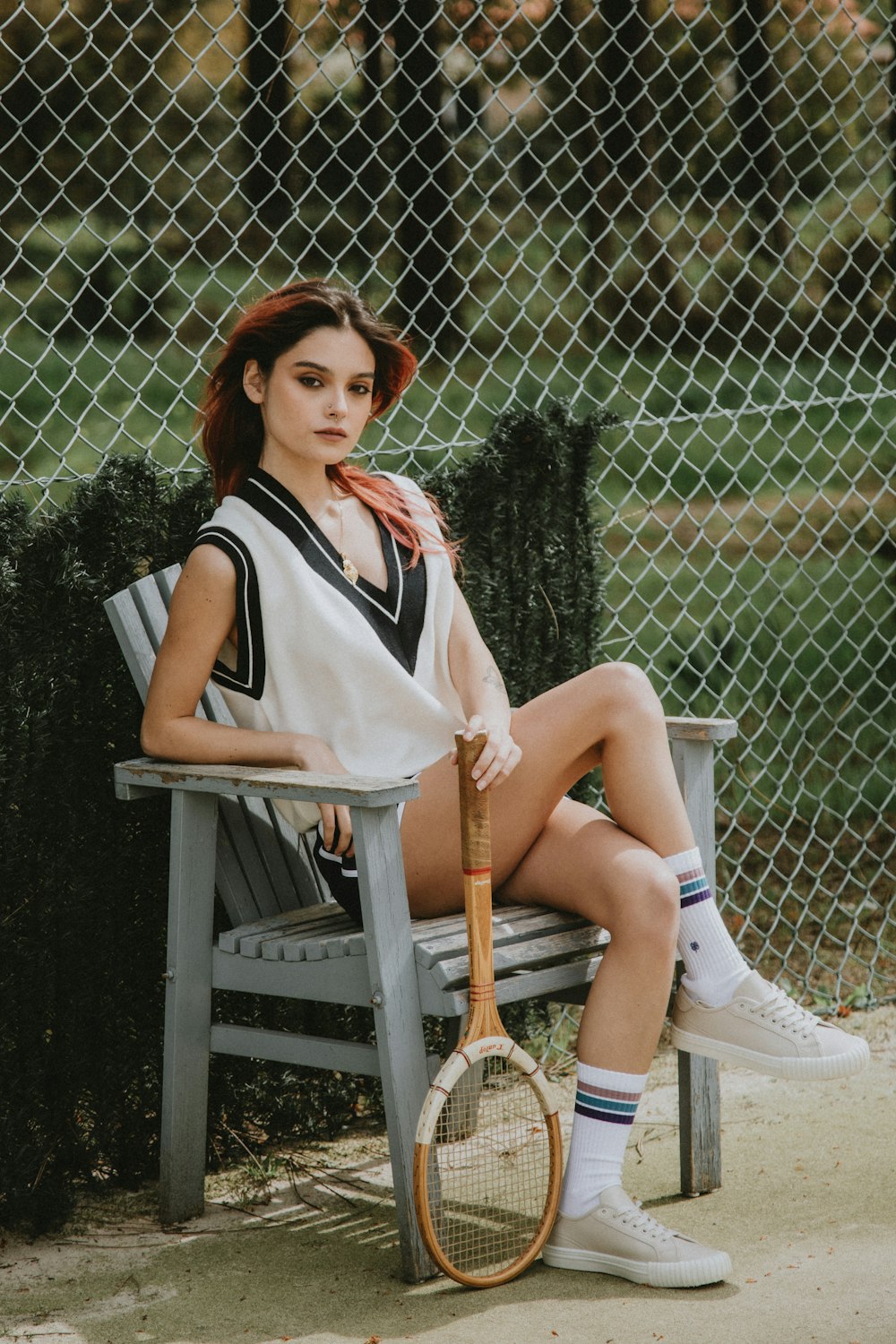 woman in white sleeveless dress sitting on brown wooden chair