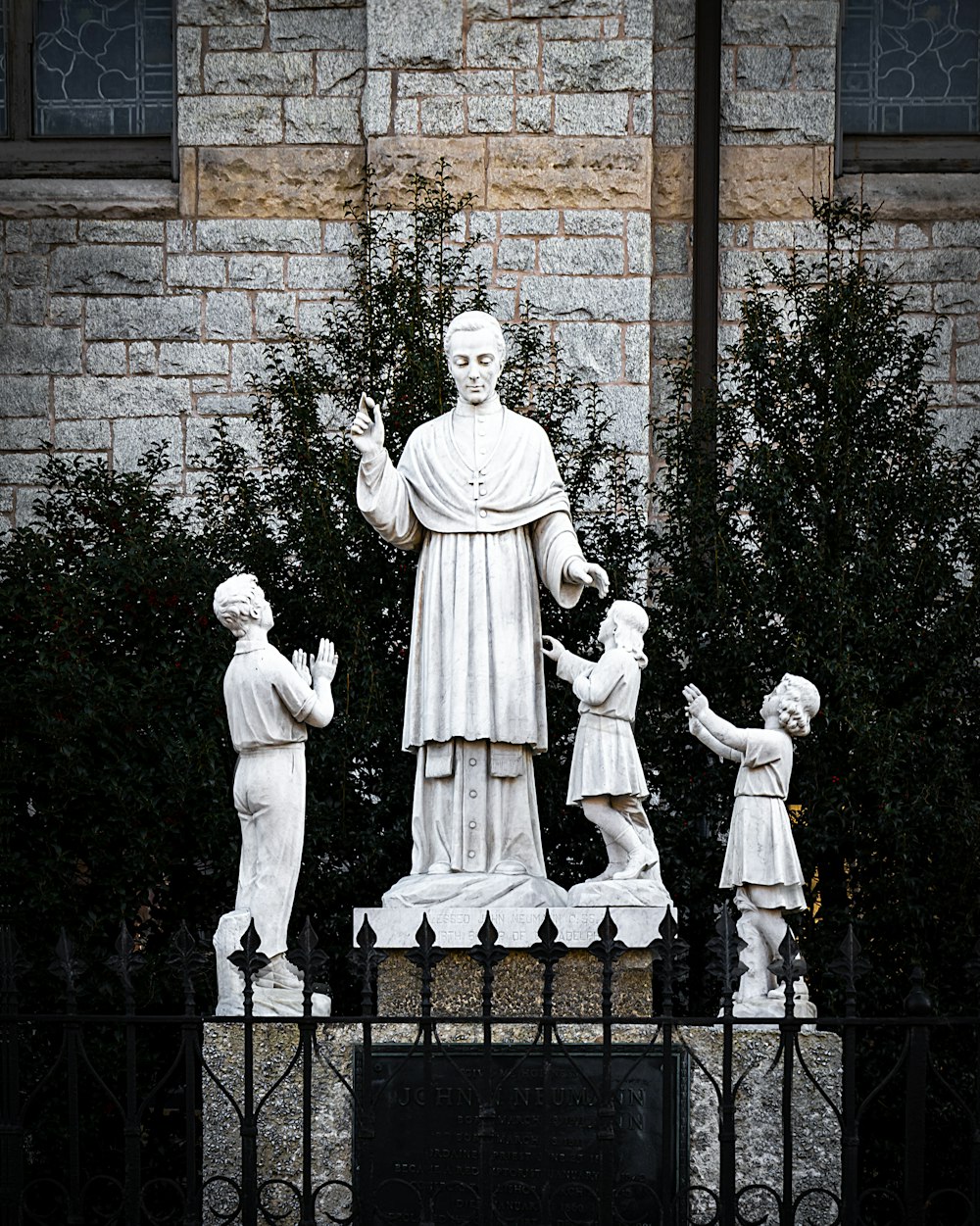 uomo in camicia bianca a maniche lunghe in piedi accanto all'uomo in statua del vestito nero