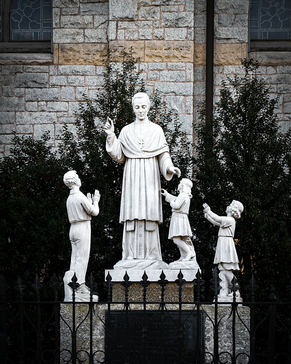 man in white long sleeve shirt standing beside man in black suit statue