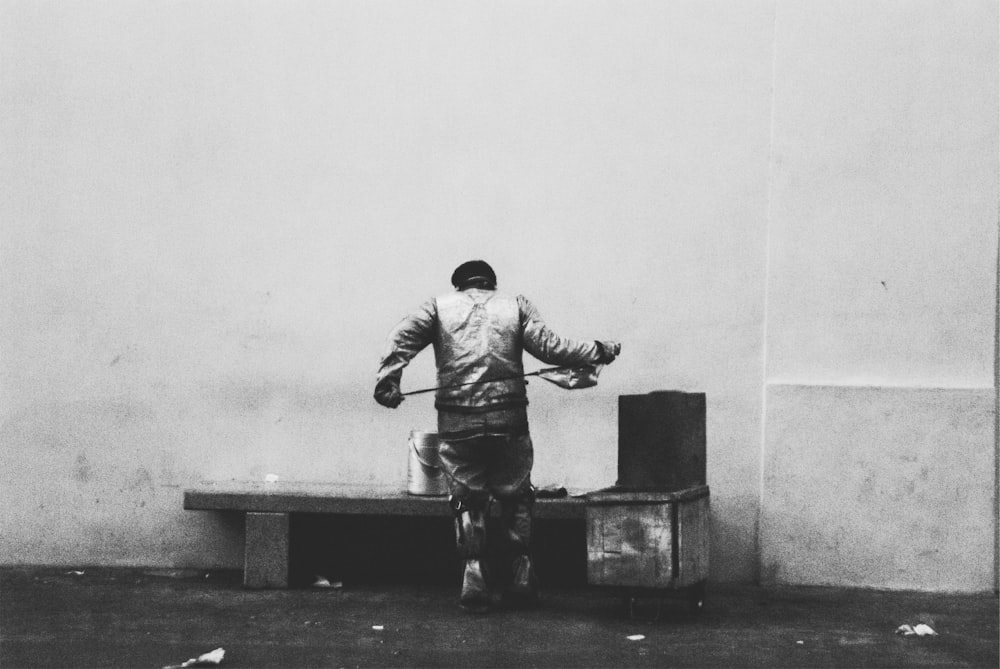 man in jacket and pants sitting on concrete bench