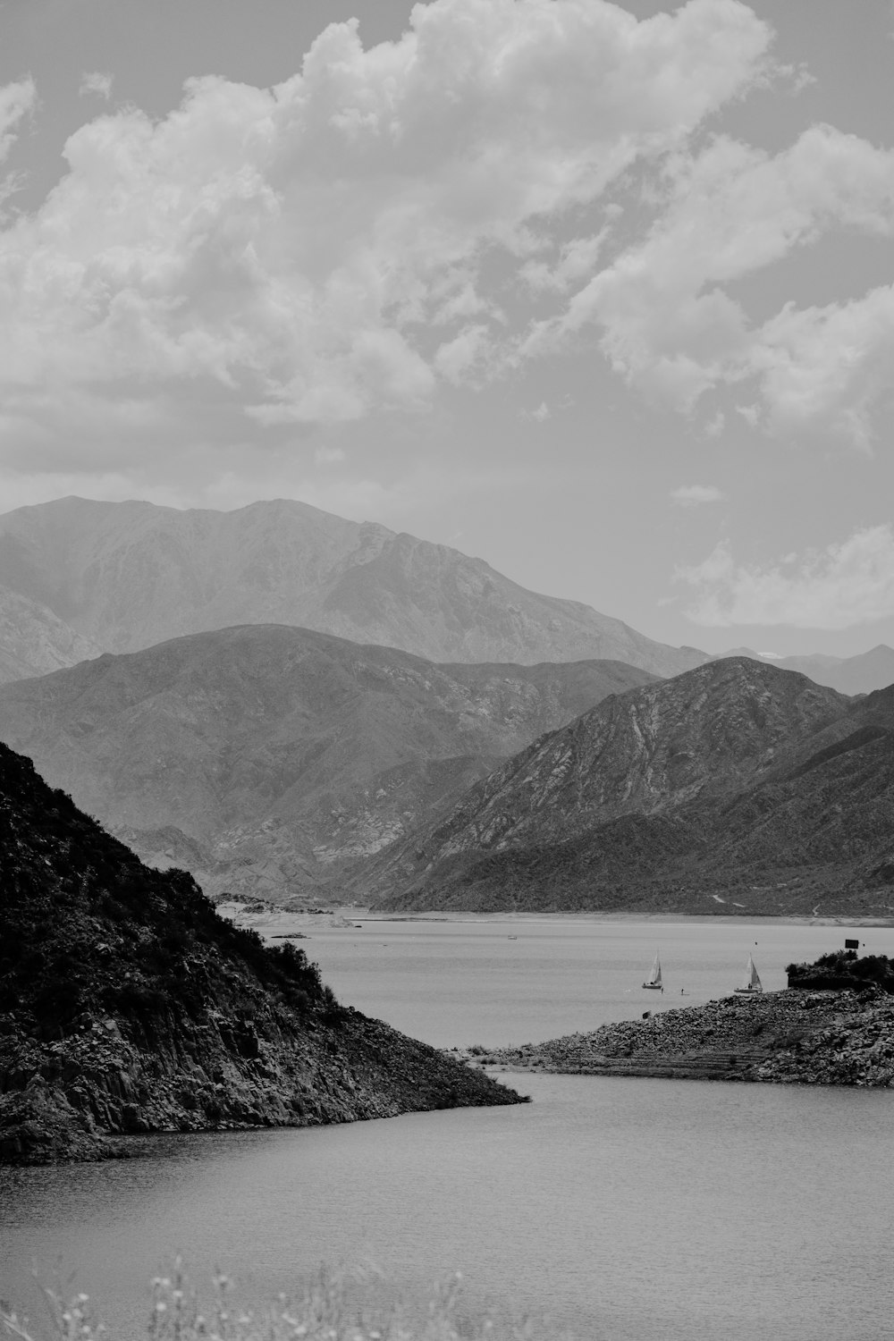grayscale photo of mountains and body of water