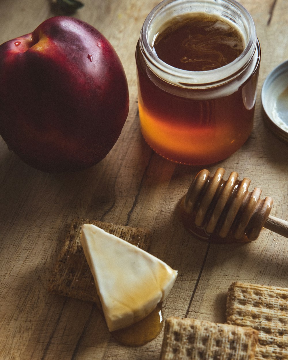 red apple beside clear glass jar with brown liquid