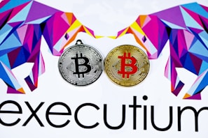 Two stylized Bitcoins, one silver and one gold, are placed side by side. Surrounding them are geometric, colorful designs resembling bulls. The lower part displays the word 'executium'.