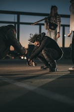 man in black jacket and black pants sitting on floor