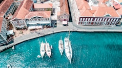 white and blue boat on water near brown concrete building during daytime