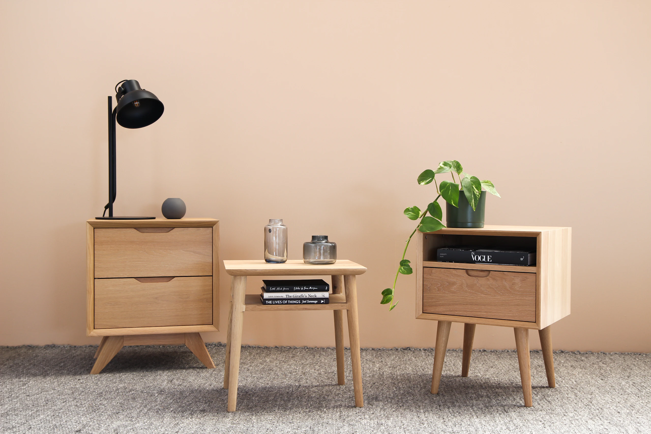 Pair of wooden nightstands with drawers against a peach wall