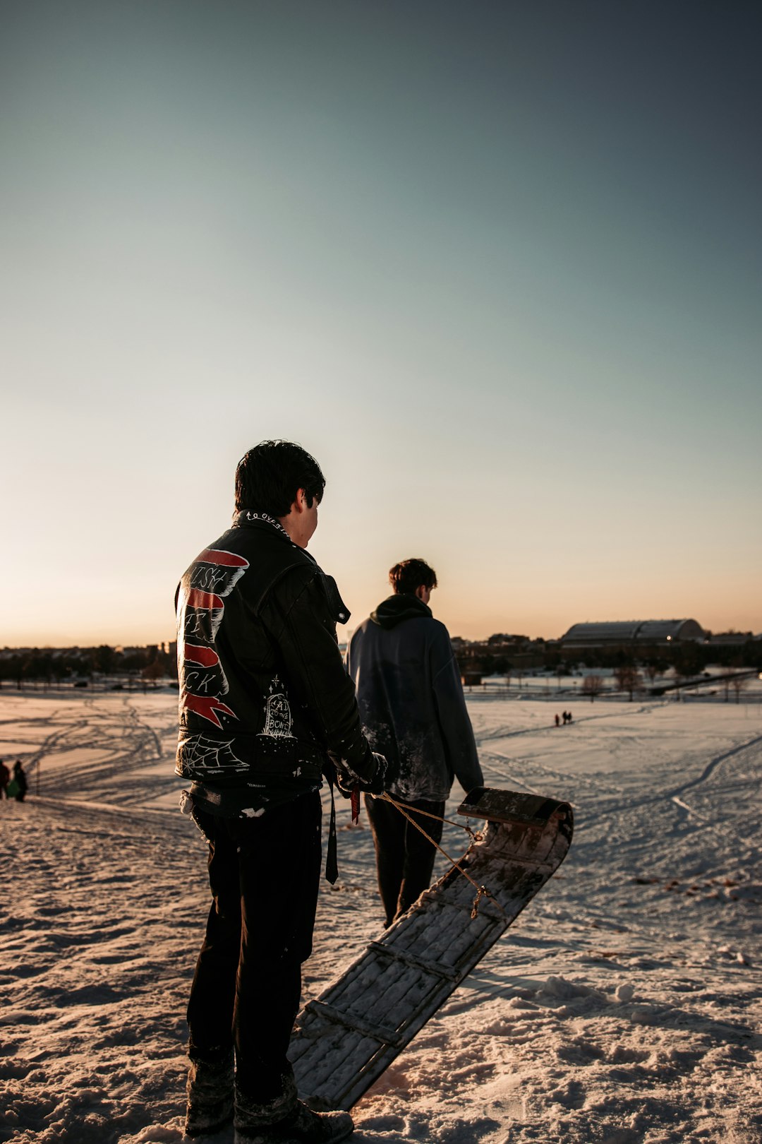 man in black jacket holding black stick standing on brown sand during daytime