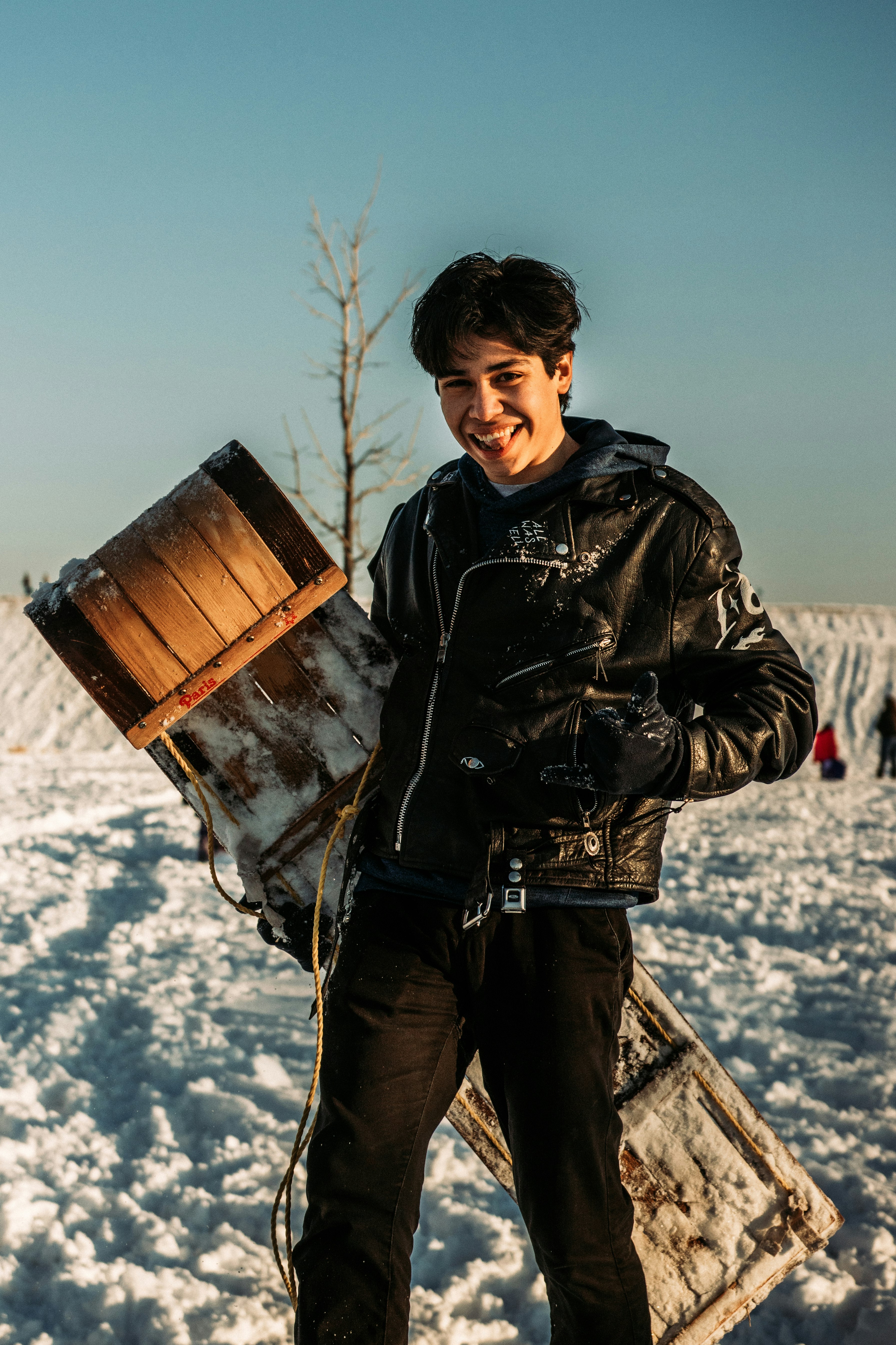 man in black leather jacket holding brown wooden box