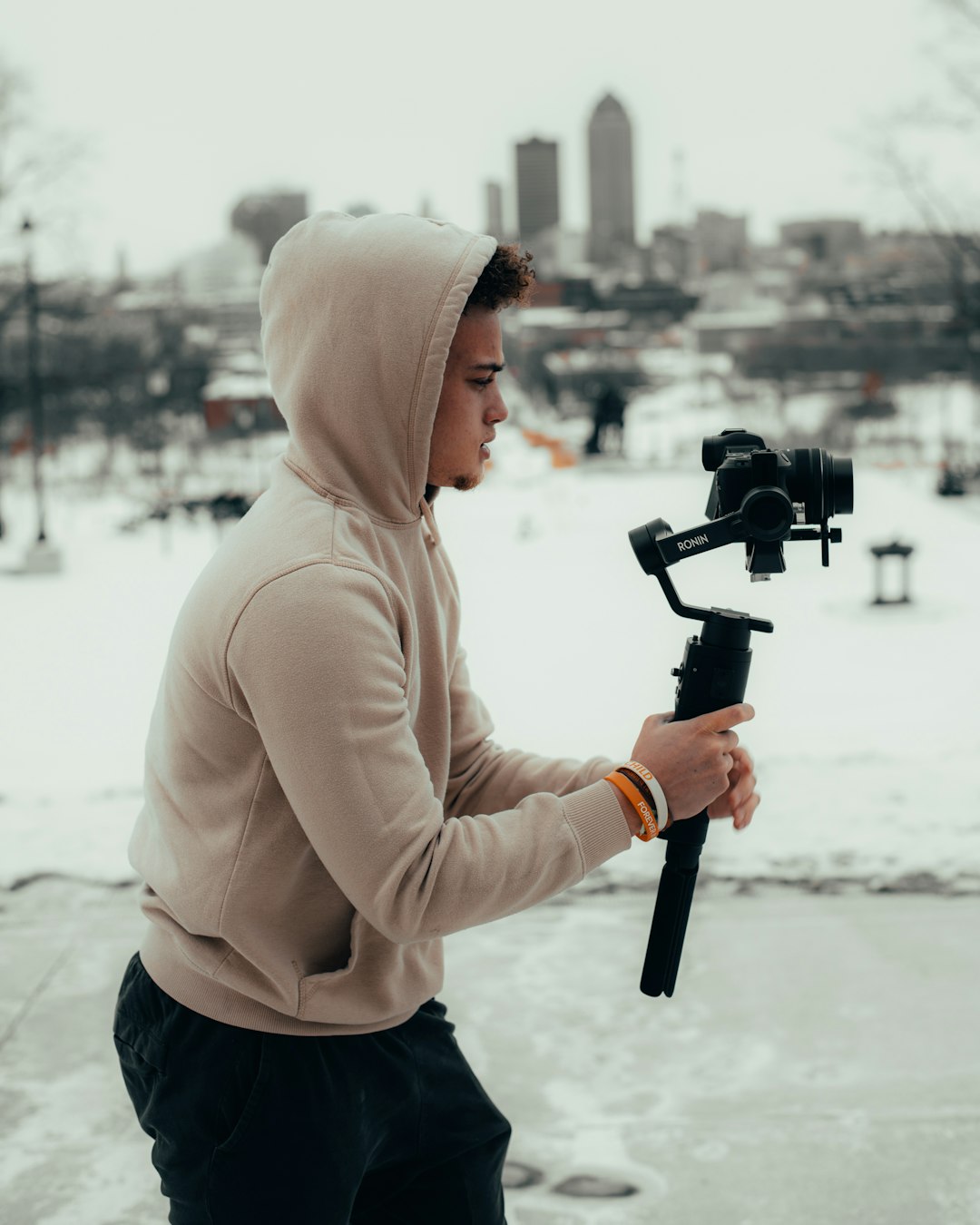 woman in beige hoodie holding black dslr camera